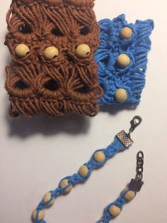 two crocheted items are sitting on a white surface, one is blue and the other is brown