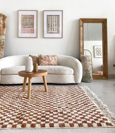 a living room with white couches and brown rugs on the floor in front of two mirrors