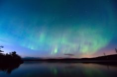 an aurora bore is seen over the water at night