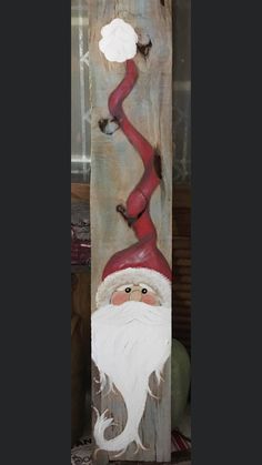 a wooden sign with a santa clause painted on it's face and hands holding the pole