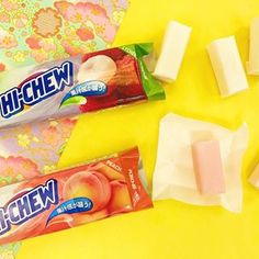 two bars of ice cream sitting next to each other on a yellow tablecloth with pink flowers