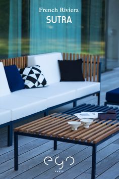 a white couch sitting on top of a wooden floor next to a blue and white table