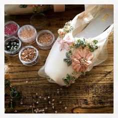 a pair of white shoes sitting on top of a wooden table next to other items