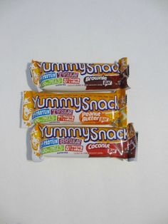 three yummy snack bars sitting next to each other on top of a white table