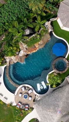 an aerial view of a pool surrounded by trees