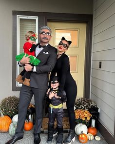 a man and two women dressed up as the characters from batman are standing in front of a house