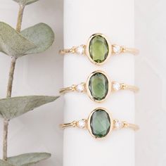 Discover the elegance of our Oval Green Sapphire Ring, featuring slightly different shades of 0.50ct sapphires in a sleek bezel setting. The bezel setting not only showcases the sapphire's vibrant green hues but also provides extra protection by encasing the gemstone in a smooth rim of 14k yellow gold. This secure setting enhances durability, making it perfect for everyday wear. The modern yet timeless design of this bezel-set ring highlights the sapphire's natural beauty while offering a refine Low Profile Bezel Ring, Bezel Set Engagement Ring Sapphire, Elegant Sapphire Oval Cabochon Rings, Modern Oval Sapphire Ring With Accent Stones, Modern Oval Sapphire Ring With Diamond, Oval Sapphire Diamond Ring With Bezel Setting, Elegant Oval Birthstone Ring With Rose Cut Diamonds, Modern Oval Emerald Ring With Accent Stones, Elegant Oval Birthstone Ring With Diamond Accents