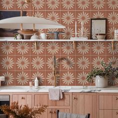 a kitchen with pink wallpaper and wooden cabinets