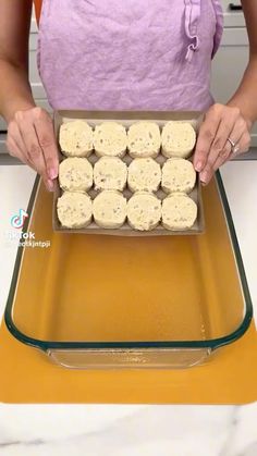 a woman holding a pan filled with cookies