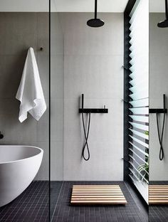 a bathroom with a walk in shower next to a white bath tub