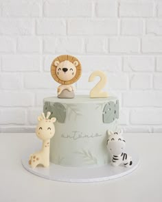 a two tiered cake with animals on top