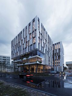 an office building with many windows on the front and side of it at night time