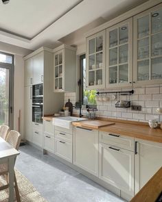 a kitchen filled with lots of white cabinets and counter top space next to a sliding glass door