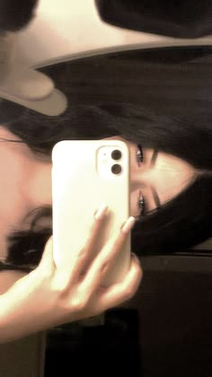 a woman taking a selfie with her cell phone in front of her face and long black hair