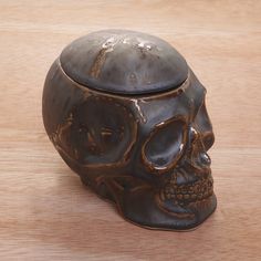 a skull shaped container sitting on top of a wooden table