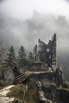 an old castle on top of a mountain in the fog