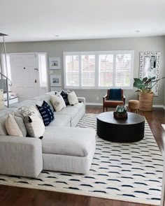 a living room filled with furniture and a large rug on top of a hard wood floor