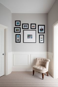 a white chair sitting in front of a wall with pictures on it's walls