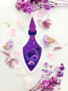 a purple bottle with a rocket ship on it surrounded by flowers