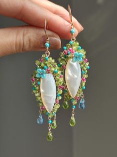 Like a beautiful dream shining with charming light. ●mother of pearl ●peridot ●turquoise ●blue topaz ●lampwork flowers ●seed beads ●total length: 79mm ● weight：6.9g Welcome to visit my Jewelry store: https://www.etsy.com/shop/Ukuly 🌸The delivery time to Most regions of North America, Australia and Europe is usually about 10-15 days. Buyers from Brazil, South Korea, and Indonesia, please provide me with your tax number through messages or notes for smooth shipment. Thank you. 🌸Please let me kno Bohemian Green Earrings With Gemstone Accents, Elegant Turquoise Jewelry With Mother Of Pearl, Green Natural Stone Earrings For Wedding, Green Natural Stones Earrings For Wedding, Elegant Turquoise Mother Of Pearl Jewelry, Lampwork Flowers, Spring Earrings, Beautiful Dream, Earrings Unique