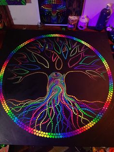 a table with an artistically designed tree of life painted on it in bright colors