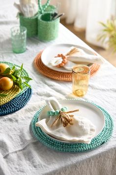 the table is set with plates, napkins and fruit on it's sides