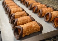 chocolate covered pastries are lined up on a baking sheet in preparation to be eaten