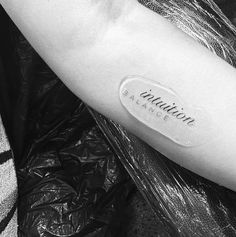 a black and white photo of a person's arm with the word salvation tattooed on it