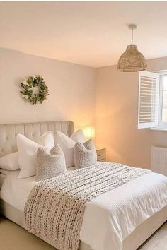 a bedroom with white bedding and pillows