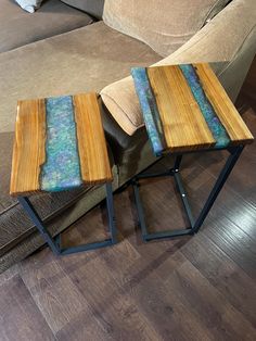 two small wooden tables sitting on top of a hard wood floor next to a couch