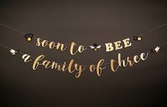 a banner that says, soon to bee a family of three hanging from a string