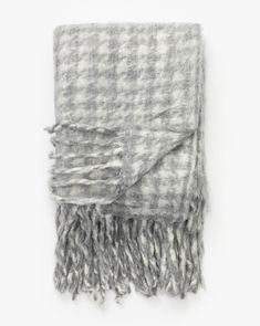 a gray and white checkered blanket with fringes on the ends, against a white background