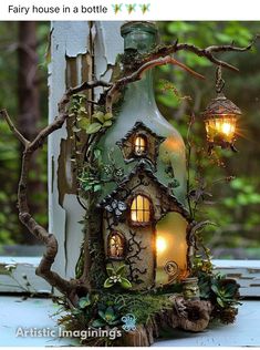 a fairy house in a bottle is lit up with lights and moss on the outside