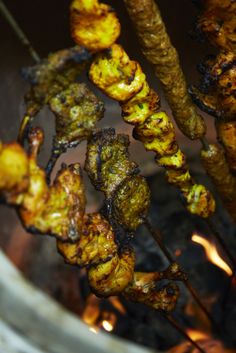 several skewers of food being cooked over an open fire