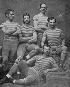 an old black and white photo of five men in striped shirts posing for the camera