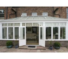 an orangery with white doors and glass windows