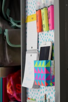 a bulletin board with pens, markers and other items on it in a closet door