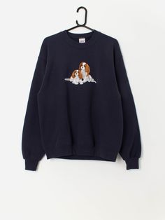 90s vintage Jerzees Spaniel embroidered navy sweatshirt. This 1990s navy Jerzees sweatshirt features two beautiful embroidered Spaniels, a round neck, long sleeves and a super soft lining. Made from a mid-weight soft cotton blend. Our recommended size: Medium Label says: Medium Condition: Very good  Material: 50% cotton, 50% polyester Measurements in inches: Pit to pit: 21 Shoulders: 21.5 Front length: 27 Back length: 26.5 Sleeve length: 24 Hem (unstretched): 17 Hem (stretched): 19 We recommend Navy Long Sleeve Sweatshirt With Embroidered Logo, Navy Long Sleeve Sweater With Embroidered Logo, Navy Crew Neck Sweater With Embroidered Logo, Vintage Embroidered Long Sleeve Sweatshirt, Vintage Long-sleeved Embroidered Sweatshirt, Vintage Crew Sweatshirt With Embroidery, Vintage Embroidered Crew Sweatshirt, Vintage Embroidered Crew Neck Sweatshirt, Vintage Embroidered Sweater For Fall