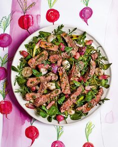 a white plate topped with meat and veggies on top of a pink table cloth