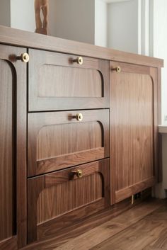 a close up of a wooden cabinet with brass handles and knobs on the doors