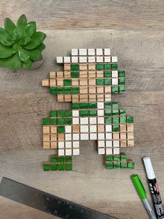 a cross made out of wooden blocks sitting on top of a table next to a knife