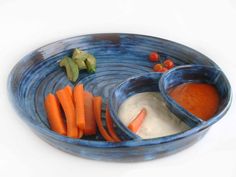 a blue bowl filled with carrots and dip