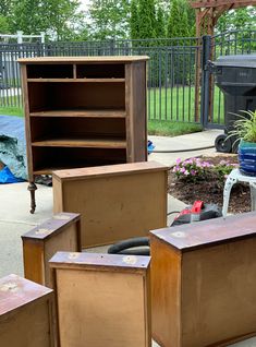 several pieces of furniture sitting on the ground in front of a fenced backyard area