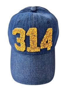 A blue denim adjustable (plus thru strap) hat with golden fleck 314 patches. Blue Hat With Logo Patch And Curved Brim, Adjustable Blue Hats With Embroidered Patch, Blue Logo Patch Baseball Cap, Blue Trucker Hat With Logo Patch, Blue Streetwear Hat With Logo Patch, Area Codes, Trucker Cap, Blue Denim, Caps Hats