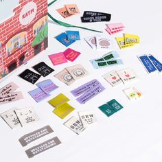 several different types of stickers and tags on a white surface with a red brick wall in the background