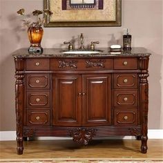 a bathroom vanity with two sinks under a painting