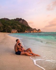 a man and woman are sitting on the beach