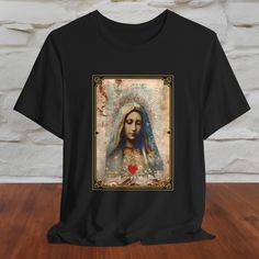 An exquisite depiction of Holy Mary, Mother of Jesus, with a sacred heart, adorns this soft and comfortable Bella + Canvas tee shirt. It makes a very special gift for Catholics, Orthodox Christians and is also venerated by devotees from other faiths such as Islam, Buddhism and Hinduism.  .: Made with 100% Airlume combed and ring-spun cotton, a lightweight fabric (4.2 oz/yd² (142 g/m that is easy to layer, breathable. Perfect for active and leisure wear.  .: The retail fit that is perfect for casual and semi-formal settings. The crew neckline adds a classic, neat style that's perfect for accessorizing. .: Bella+Canvas manufactures all its products in the US and internationally in humane, no-sweat-shop, sustainable way and is part of the Fair Labor Association as well as Platinum WRAP certif Graphic Tee Printed T-shirt For Gift, Graphic Tee Printed T-shirt As Gift, Printed Short Sleeve T-shirt Gift, Catholic Tshirts, Jesus Mother, Jesus Tees, Sainte Marie, Holy Mary, Heart T Shirt