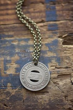 a silver coin necklace on a wooden surface