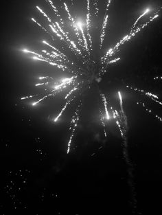 black and white photograph of fireworks in the night sky